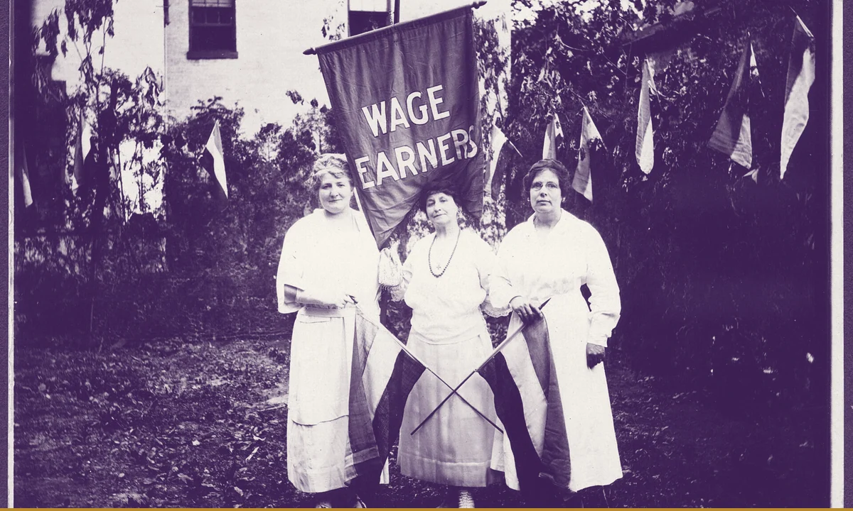 Three women in sashes standing together.