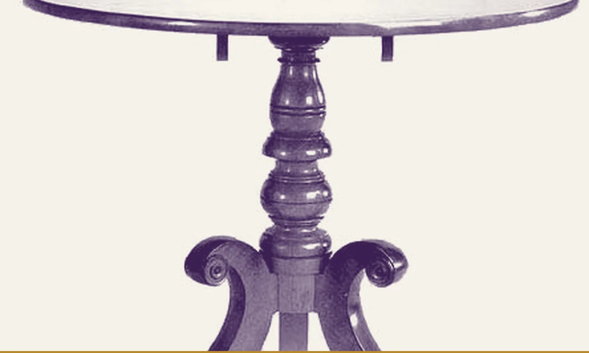 A small mahogany table on display in a museum case.