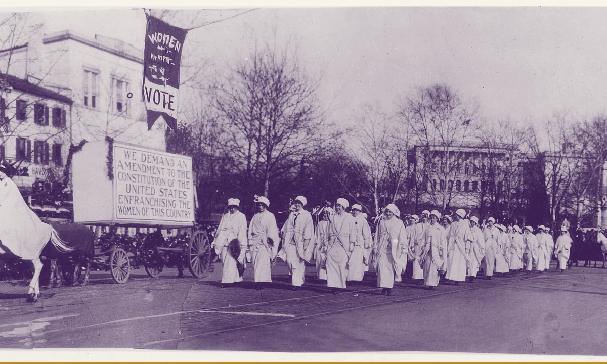 Marchers and banners at the head of a large street procession.