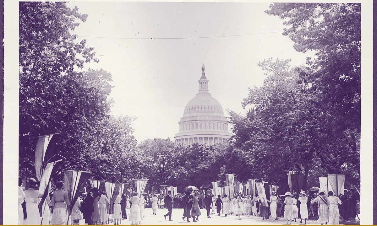 Women walking in file carrying lettered banners.